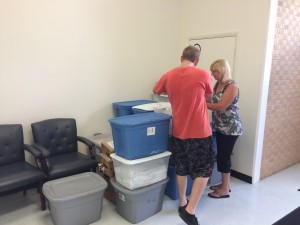 A portion of the donated school supplies with Cromwell Employees Dustin Osteen and Bev Drake.