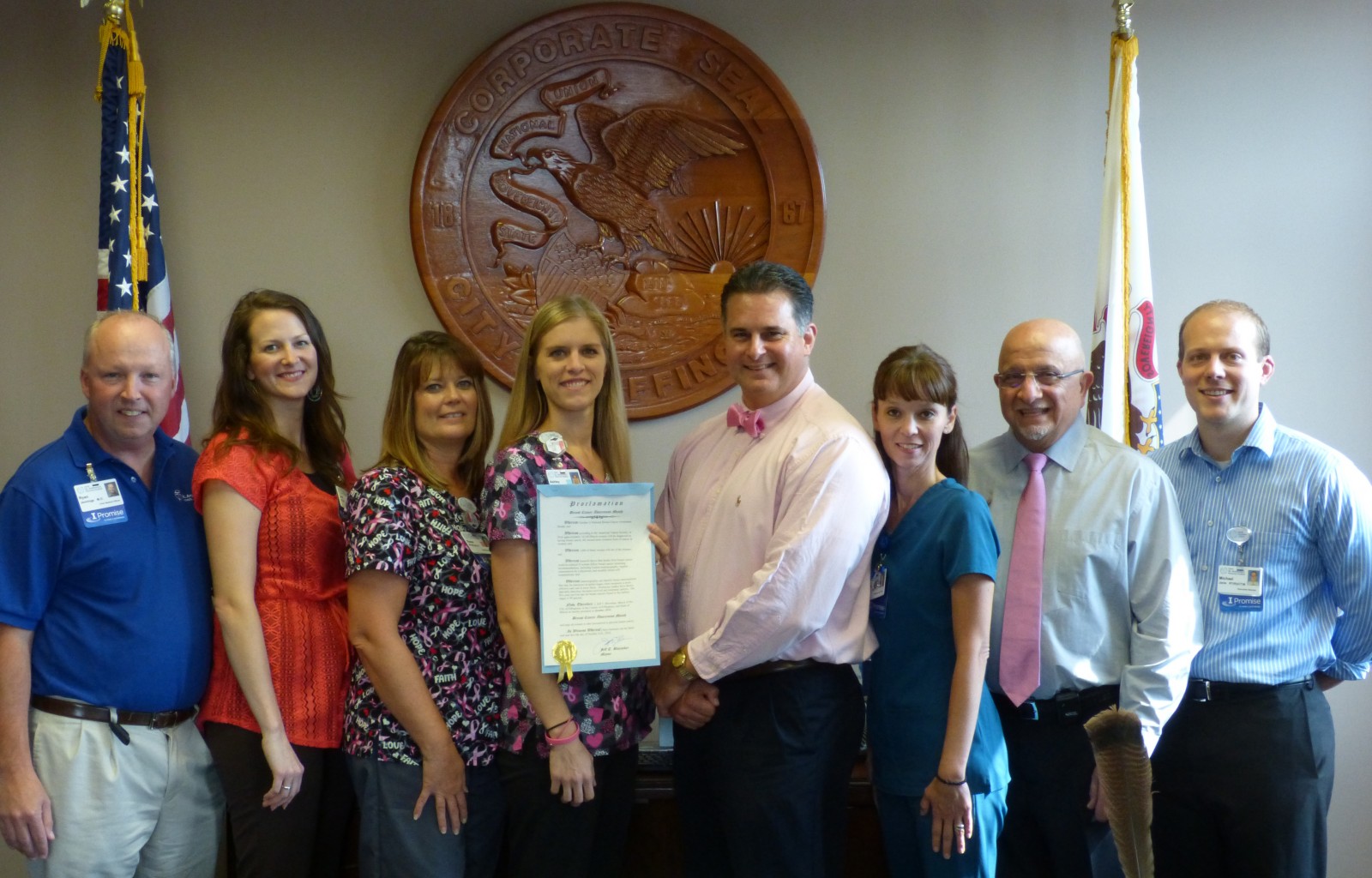 Effingham Mayor Jeff T. Bloemker, fourth from right, signed a proclamation designating October 2016 as Breast Cancer Awareness Month.  Joining the Mayor for the signing from HSHS St. Anthony’s Memorial Hospital were, standing left to right, Dr. Ryan Jennings, Chief Medical Officer; Jill Navarro, Cancer Program Specialist; Susan Koontz Women’s Wellness Center Facilitator; Ashley Davis, Women’s Wellness Center Nurse Navigator; Mayor Bloemker; Kelly Sager, Chief Nursing Officer, Dr. Ruben Boyajian, Medical Director of Women’s Wellness and Cancer Care Services; and Mike Janis, Executive Director of Outpatient and Ancillary Services.
