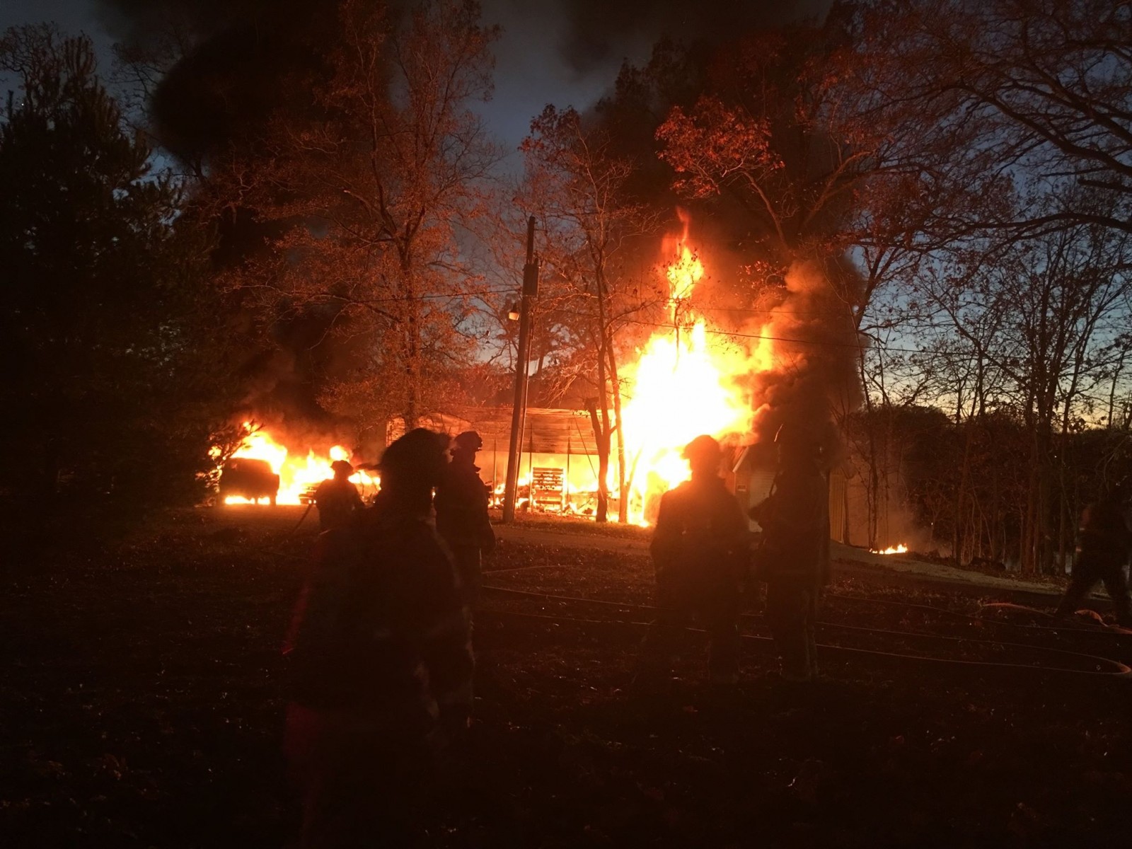 Firefighters attempt to contain the blaze at a Pana Lake residence on Sunday. Photo Courtesy of a Pana Police Department Press Release.